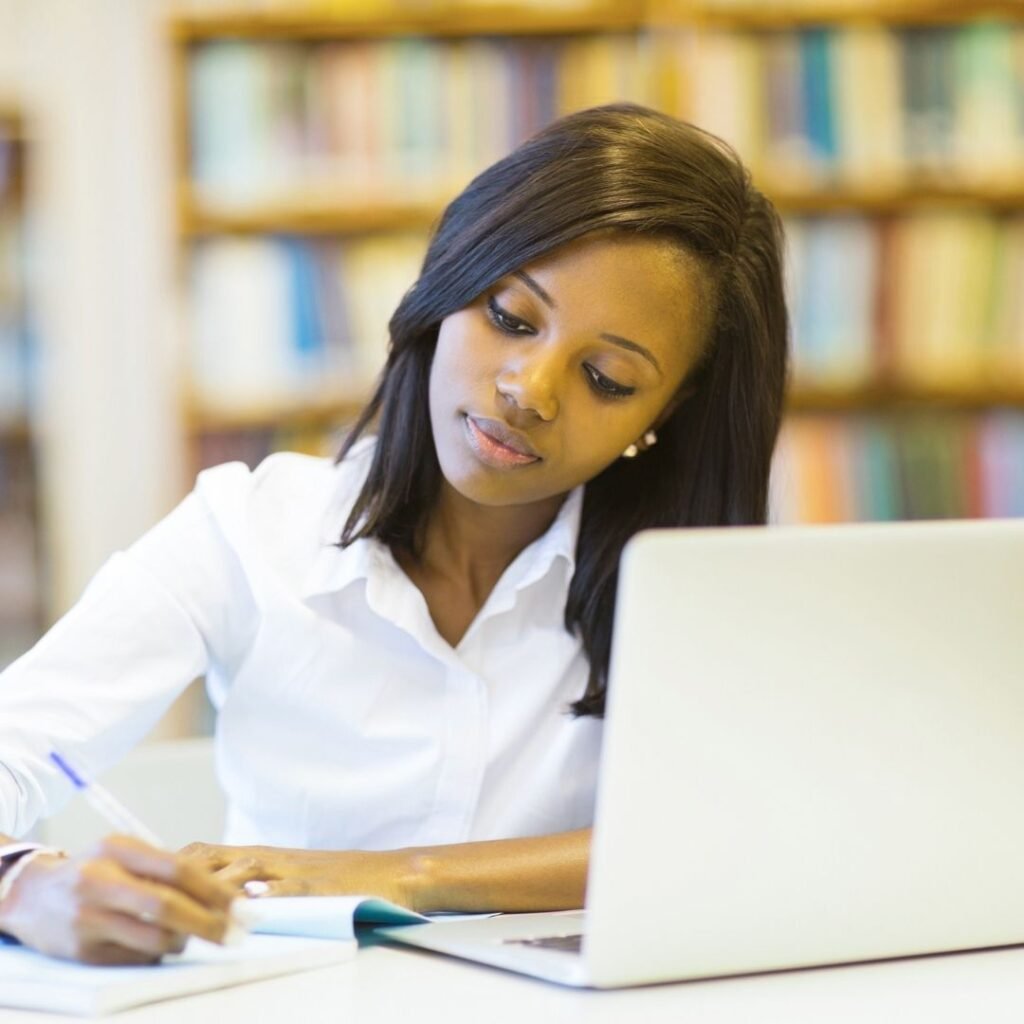 student in library with laptop