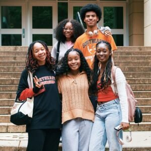 Students posing for a group photo outside of a campus building