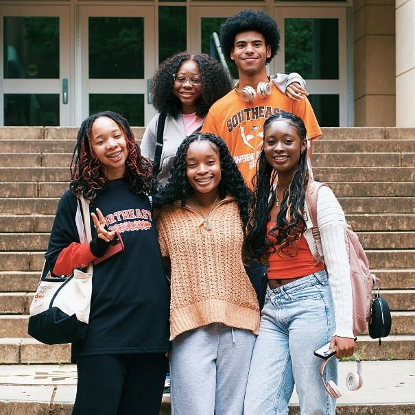 Students posing for a group photo outside of a campus building